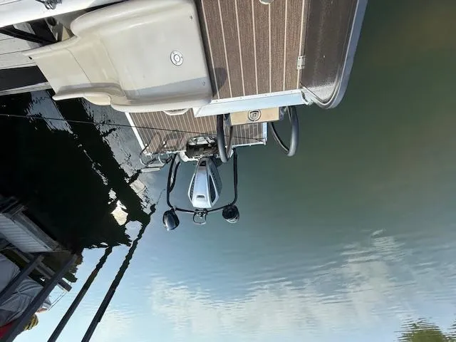 Slide: The Image of 2022 Premier 250 Sunsation pontoon boat docked on calm water. - 32