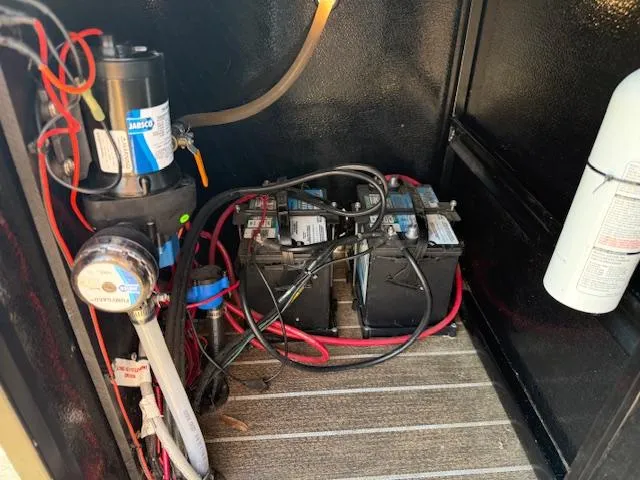 Slide: The Image of Electrical components and batteries inside a 2022 Premier 250 Sunsation boat compartment. - 35