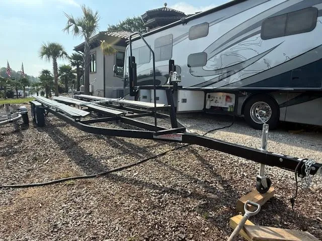 Slide: The Image of Trailer for 2022 Premier 250 Sunsation boat parked beside a large RV. - 38