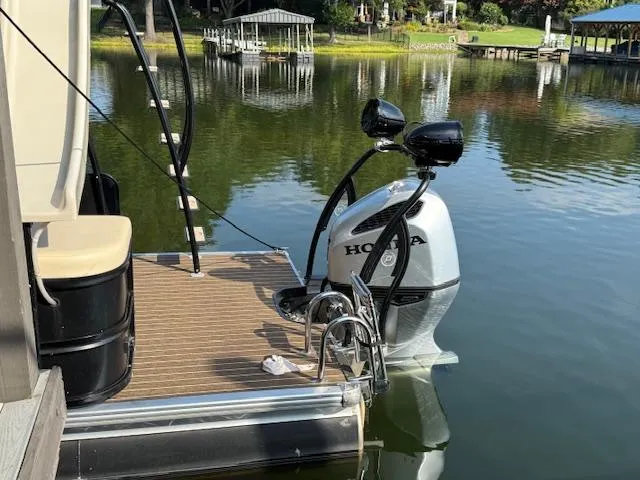 Slide: The Image of 2022 Premier 250 Sunsation pontoon boat with Honda outboard motor on a calm lake. - 7
