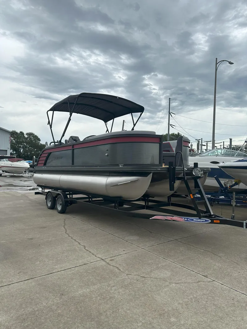 The Image of 2026 Flagship D22CU Extended Deck pontoon boat on trailer under cloudy sky. - 0