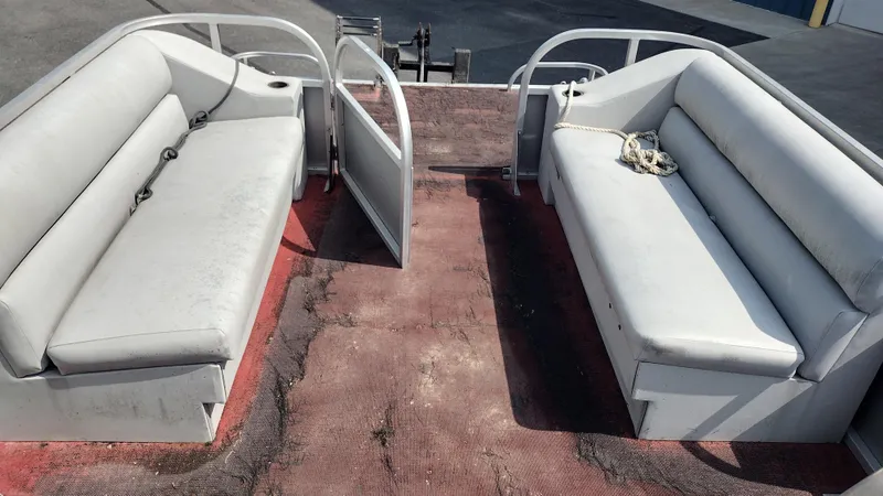 Slide: The Image of 1991 Grumman Funship 24' pontoon boat interior with white seating and red flooring. - 10