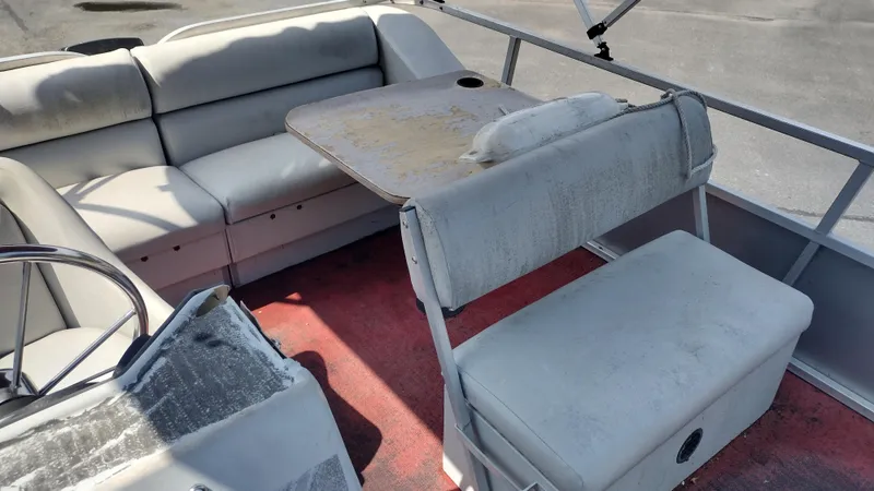 Slide: The Image of Interior of a 1991 Grumman Funship 24' with worn seating and table. - 11