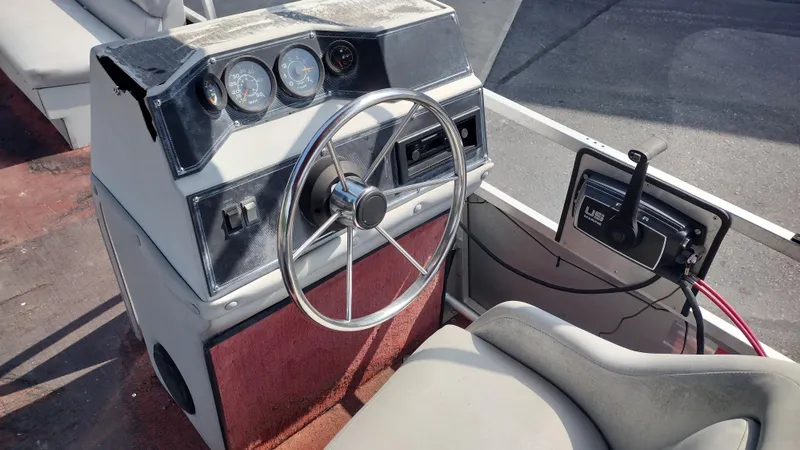 Slide: The Image of 1991 Grumman Funship 24' boat dashboard with steering wheel and control panel. - 12