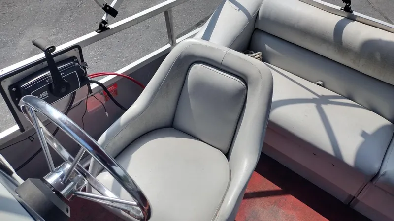 Slide: The Image of 1991 Grumman Funship boat interior with steering wheel and cushioned seating. - 13