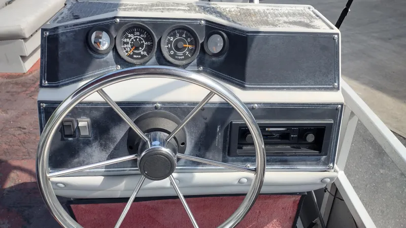 Slide: The Image of 1991 Grumman Funship 24' boat dashboard with steering wheel and gauges. - 14