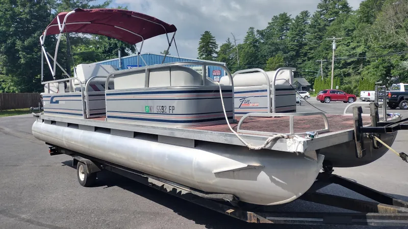 Slide: The Image of 1991 Grumman Funship 24' pontoon boat with canopy on trailer, parked outdoors. - 3