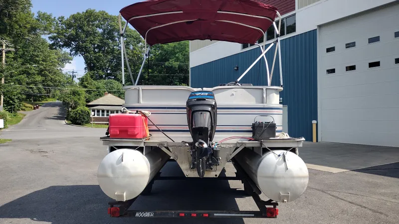 Slide: The Image of 1991 Grumman Funship 24' pontoon boat with red canopy, parked on trailer. - 6
