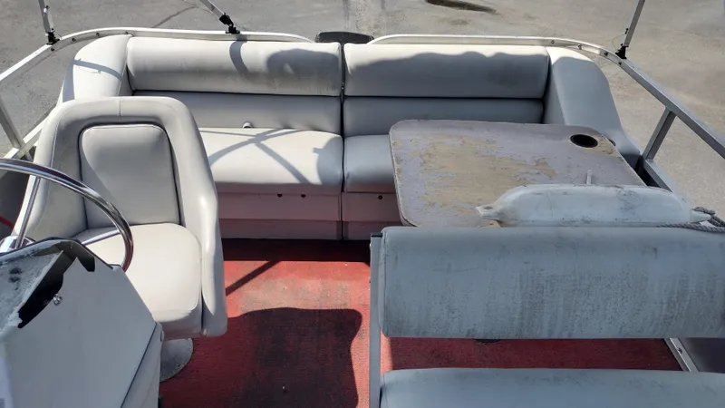 Slide: The Image of 1991 Grumman Funship interior with worn seating and table, featuring a red carpet. - 8