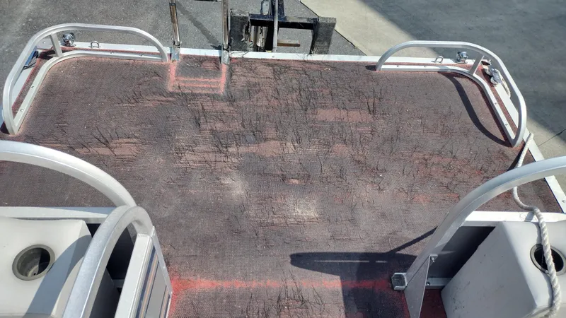 Slide: The Image of 1991 Grumman Funship 24' deck with worn surface and metal railings. - 9