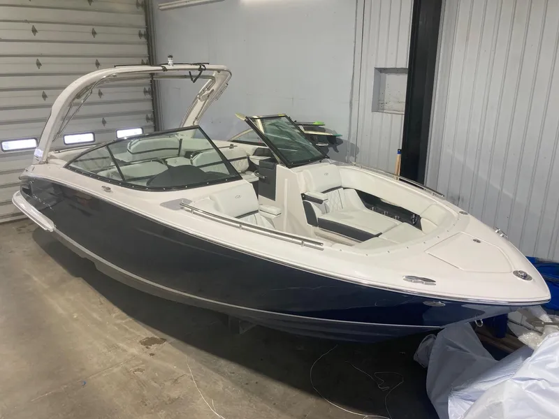 Slide: The Image of 2023 Regal 2800 Bowrider boat in a garage, showcasing sleek design and spacious seating. - 0
