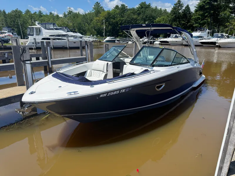 Slide: The Image of 2023 Regal 2800 Bowrider boat docked in a marina, surrounded by other boats. - 1