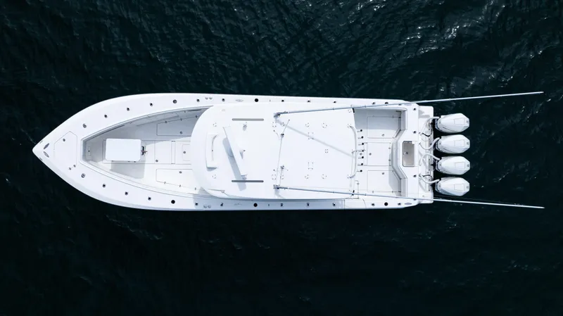 Slide: The Image of Aerial view of 2021 SeaVee 390 boat on dark water, showcasing sleek design and triple engines. - 18