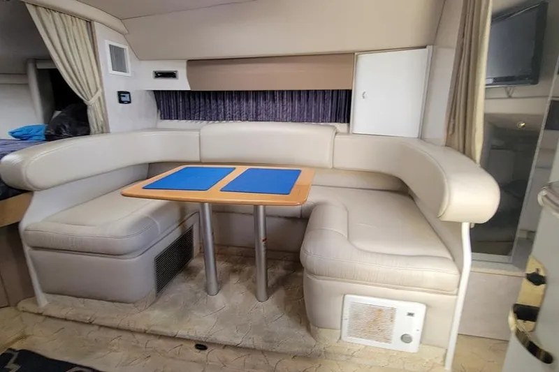Slide: The Image of Interior of a 2003 Formula 31 Performance Cruiser with beige seating and a wooden table. - 11