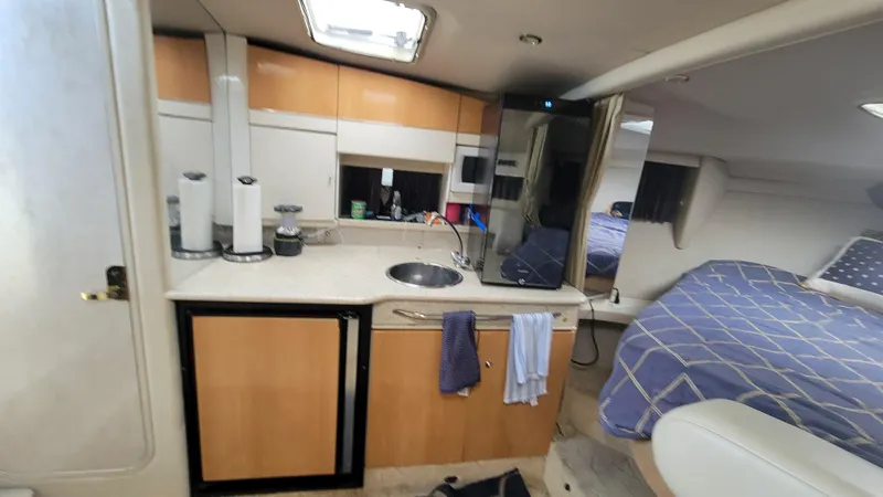 Slide: The Image of Interior of a 2003 Formula 31PC boat featuring a compact kitchen and cozy sleeping area. - 15
