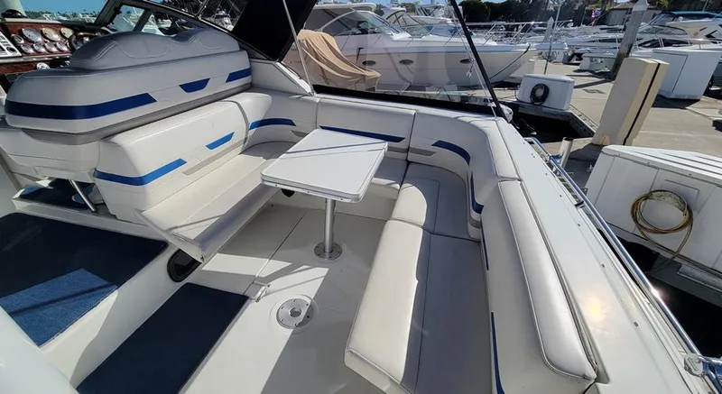 Slide: The Image of 2003 Formula 31PC boat interior with white and blue seating, docked at marina. - 2