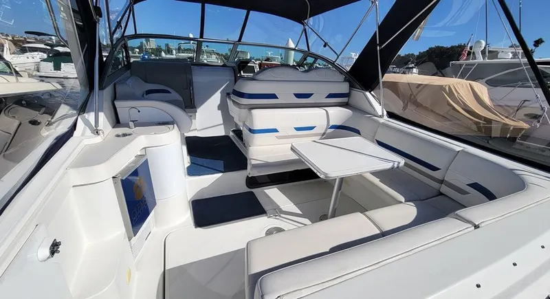 Slide: The Image of 2003 Formula 31PC boat interior with seating and table, docked under clear blue sky. - 3