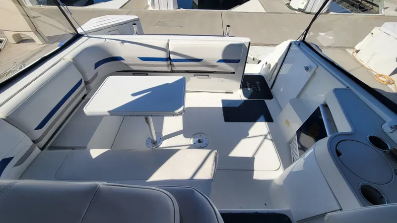Slide: The Image of 2003 Formula 31PC boat interior with seating and table, featuring white and blue upholstery. - 5
