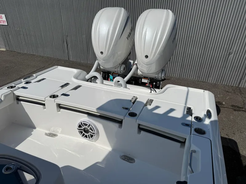 Slide: The Image of 2026 Tidewater 2700 Carolina Bay boat with dual Yamaha outboard engines, docked near a corrugated wall. - 10