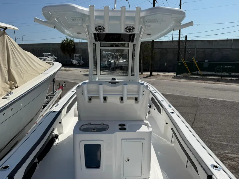 Slide: The Image of 2026 Tidewater 2700 Carolina Bay boat, white interior, docked outdoors, featuring T-top and rod holders. - 13