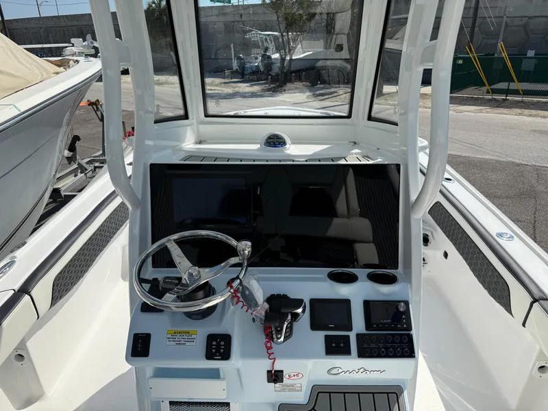 Slide: The Image of 2026 Tidewater 2700 Carolina Bay boat console with steering wheel and navigation controls. - 15