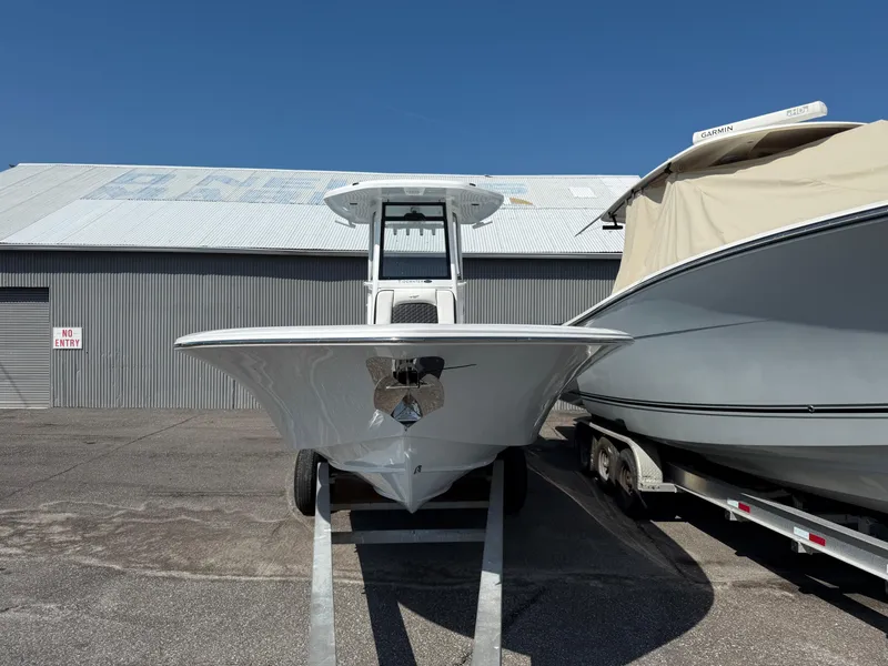 Slide: The Image of 2026 Tidewater 2700 Carolina Bay boat on trailer, parked outdoors near a metal building. - 2