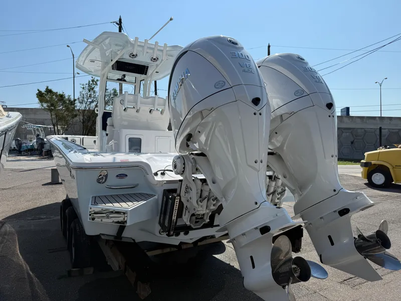 Slide: The Image of 2026 Tidewater 2700 Carolina Bay boat with dual outboard engines, parked outdoors. - 6
