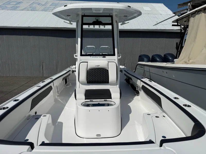 Slide: The Image of 2026 Tidewater 2700 Carolina Bay boat interior with seating and console, docked outdoors. - 8