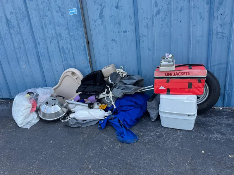 Slide: The Image of Outdoor gear and life jackets beside a blue wall, including a cooler and various equipment. - 13