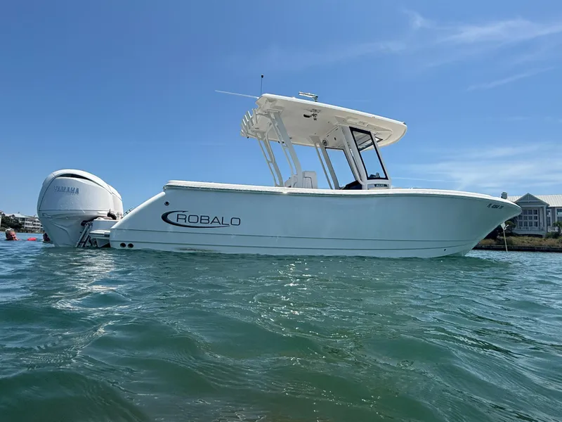 Slide: The Image of 2024 Robalo R270 Center Console boat on water, side view, clear sky background. - 3