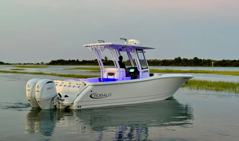 Slide: The Image of 2024 Robalo R270 Center Console boat on calm water at sunset. - 5