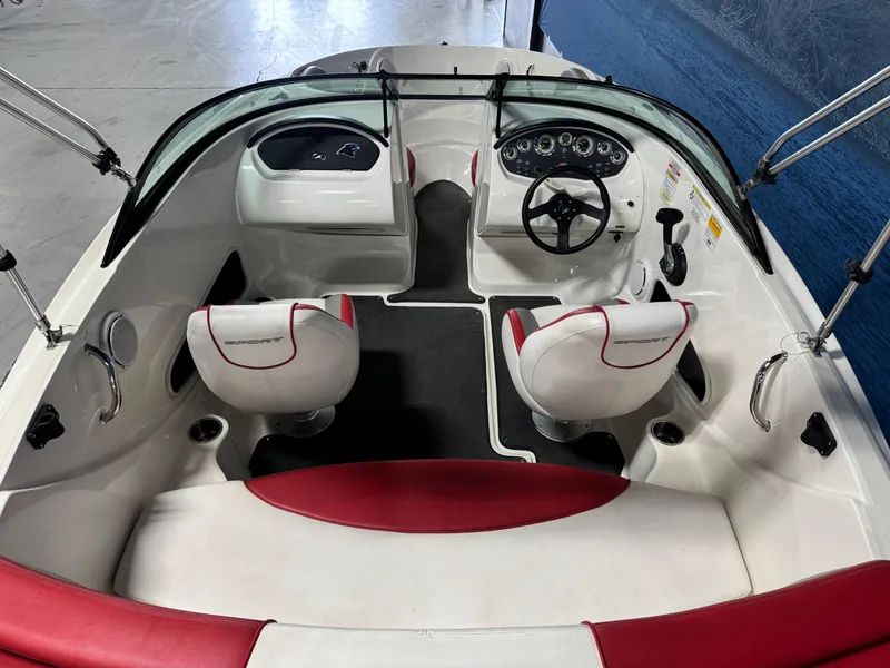 Slide: The Image of 2012 Sea Ray 185 Sport boat interior with red and white seating, steering wheel, and dashboard. - 10