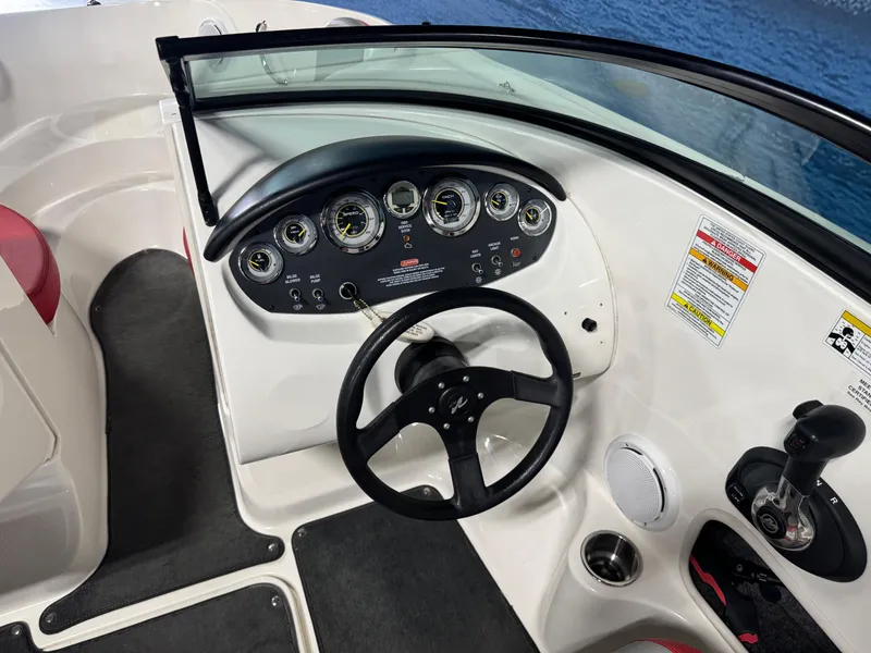 Slide: The Image of 2012 Sea Ray 185 Sport dashboard with steering wheel and control panel. - 15
