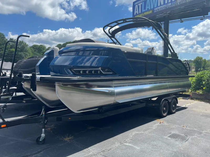 The Image of 2026 Harris Grand Mariner 230 pontoon boat on trailer under blue sky. - 0
