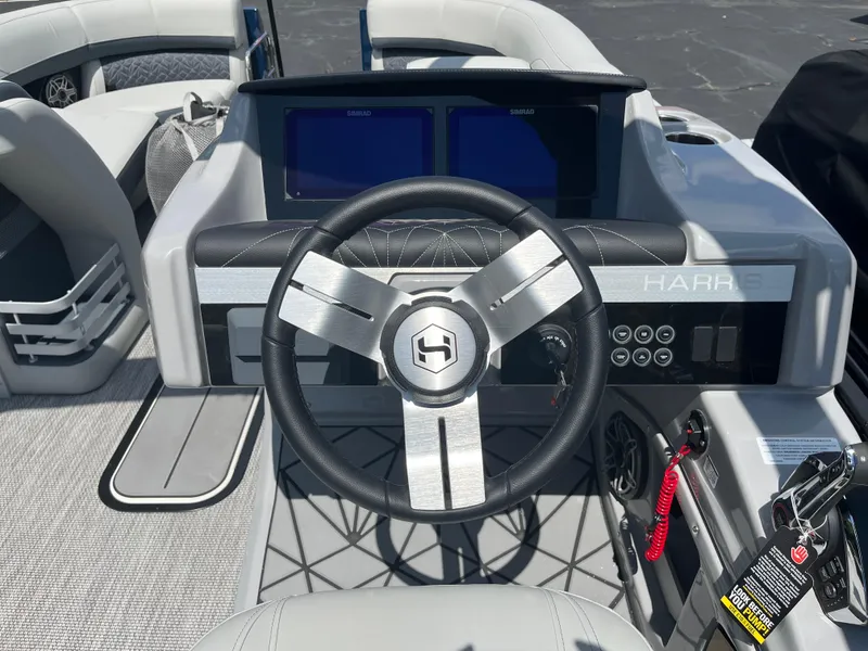 Slide: The Image of Steering console of 2026 Harris Grand Mariner 230 boat with modern controls and displays. - 15