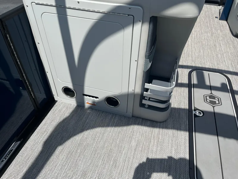 Slide: The Image of Interior of 2026 Harris Grand Mariner 230 boat, featuring storage compartments and carpeted flooring. - 16