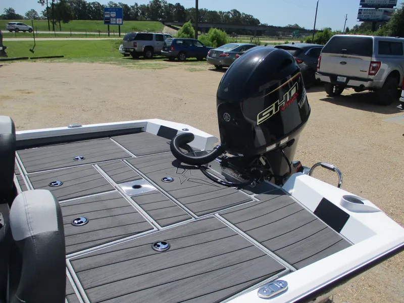 Slide: The Image of 2026 Vexus AVX1880 boat with sleek deck and powerful outboard motor in a parking area. - 14