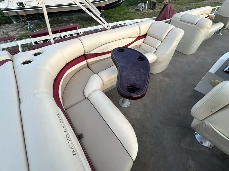 Slide: The Image of 2009 Bennington 2577RFi boat interior with plush seating and a central table. - 9