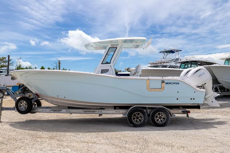 Slide: The Image of 2026 Sea Fox 268 Commander boat on trailer, parked outdoors under a blue sky. - 5
