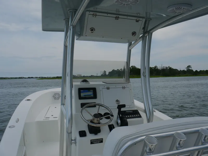 Slide: The Image of 2018 KenCraft Challenger 21 boat interior with steering wheel and navigation system on water. - 13