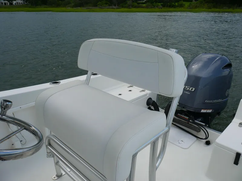 Slide: The Image of 2018 KenCraft Challenger 21 boat interior with seating and storage, on calm water. - 7