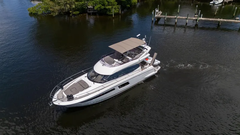 Slide: The Image of 2018 Prestige 500 Flybridge yacht cruising on a calm waterway. - 4