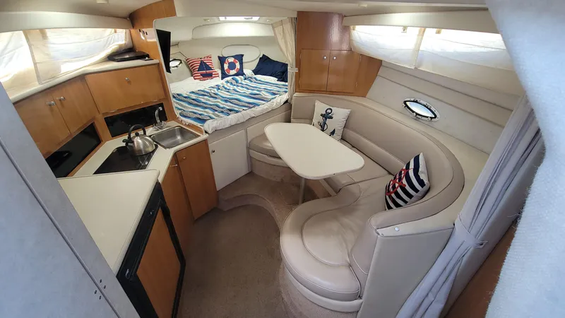 Slide: The Image of 2001 Bayliner 3055 Ciera interior with kitchenette, seating area, and cozy sleeping quarters. - 14