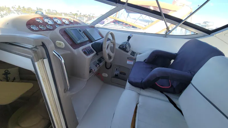 Slide: The Image of 2001 Bayliner 3055 Ciera cockpit with steering wheel, gauges, and cushioned seating. - 9