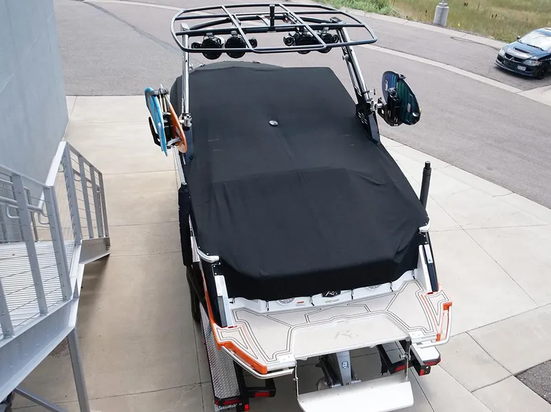 Slide: The Image of 2022 Cobalt R6 Surf boat covered, parked on concrete near a staircase. - 2