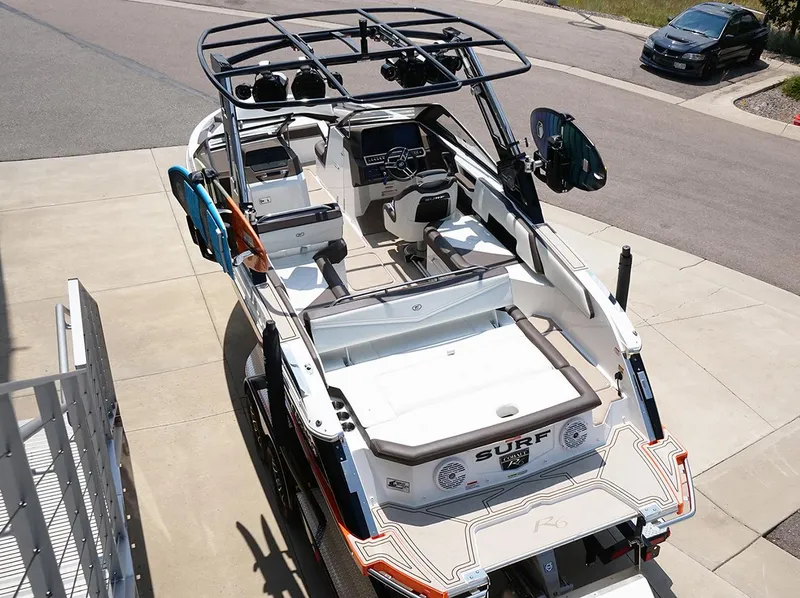 Slide: The Image of 2022 Cobalt R6 Surf boat parked on driveway, showcasing sleek design and spacious interior. - 21