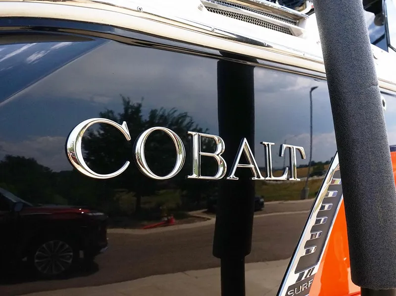 Slide: The Image of 2022 Cobalt R6 Surf boat with chrome logo on sleek black surface. - 7