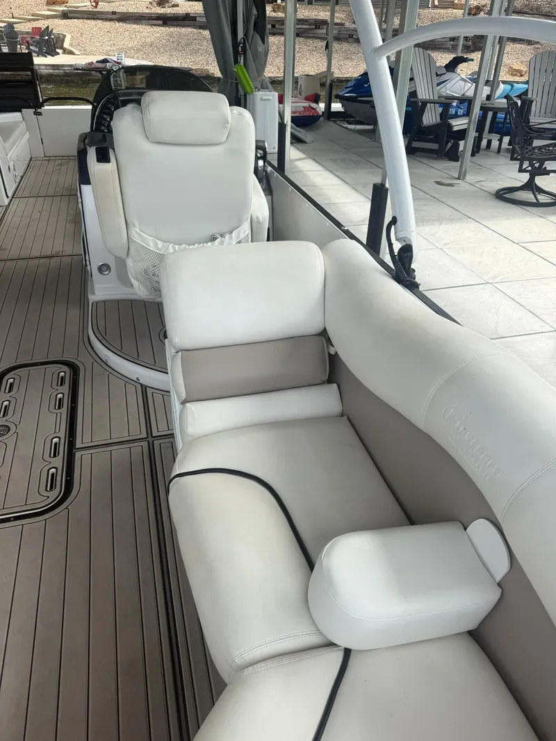 Slide: The Image of 2019 PlayCraft 29 Infinity boat interior with white seating and wood-style flooring. - 2