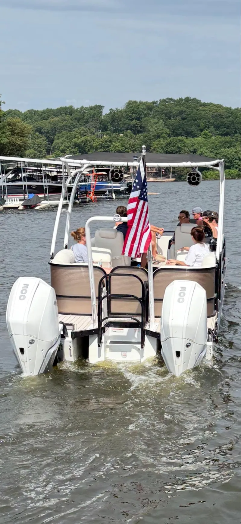 Slide: The Image of 2019 PlayCraft 29 Infinity boat cruising on a lake with passengers and an American flag. - 7