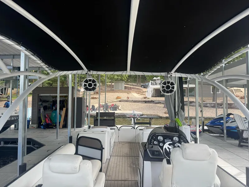 Slide: The Image of 2019 PlayCraft 29 Infinity boat interior with canopy, docked near a lakeside. - 9